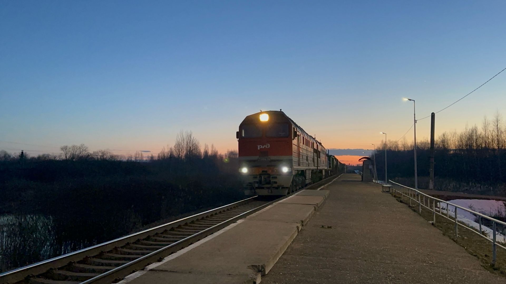 «На фоне триколор-заката» Тепловоз 2ТЭ116УД с перегоняемым ТГМ4Б-0931 и грузовым поездом на перегоне