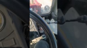 синий трактор едет за песком