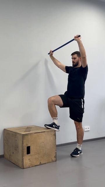 Динамика на тумбе с гимнастической палкой над головой (наклон к опорной ноге)