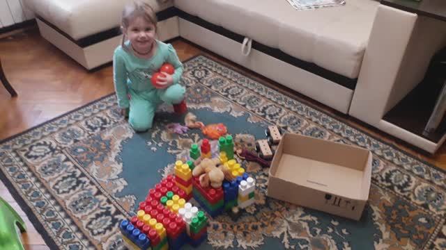 Двухлетняя Ева обожает играть в лего и показывать фокусы. Домик для собачки, которая спит на крыше.