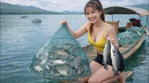 Красивая девушка в одиночку забрасывает сети с ловушками для осьминогов на огромном озере.