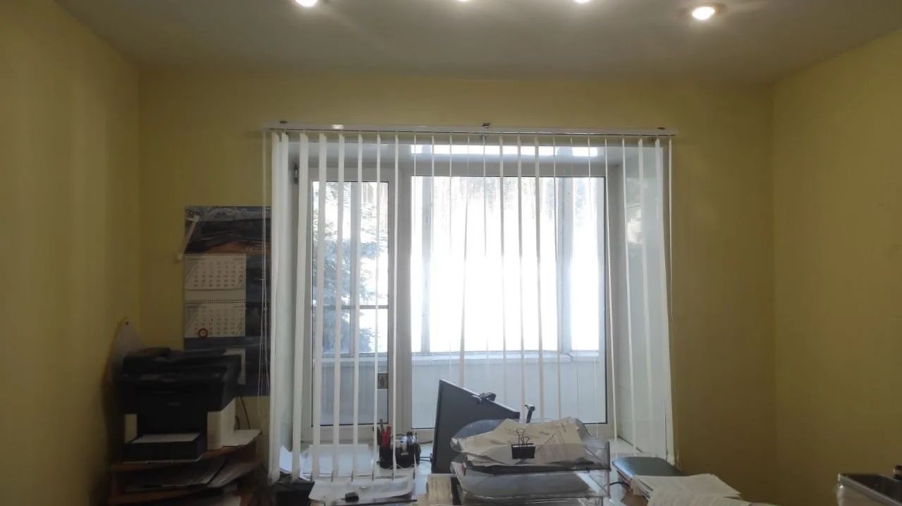 Бежевые вертикальные тканевые жалюзи для защиты от солнца в офисное помещение.