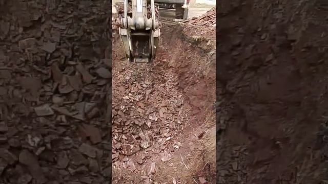 Настоящий экскаватор копает скалу. Яма под канализацию.