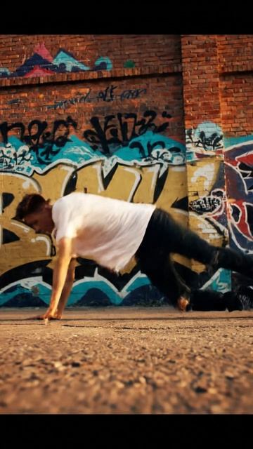 Танцор в джинсах и футболке исполняет #хипхоп на фоне #граффити под ритмичный трек с басами