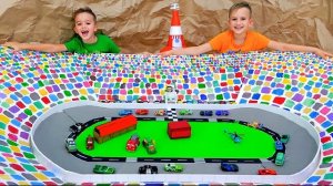 Влад и Ники играют с игрушечными машинками и строят гоночную трассу.