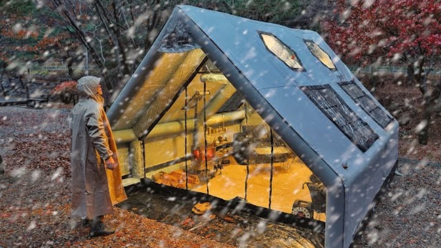 Зимний снежный кемпинг с дровяной печью в надувной палатке.