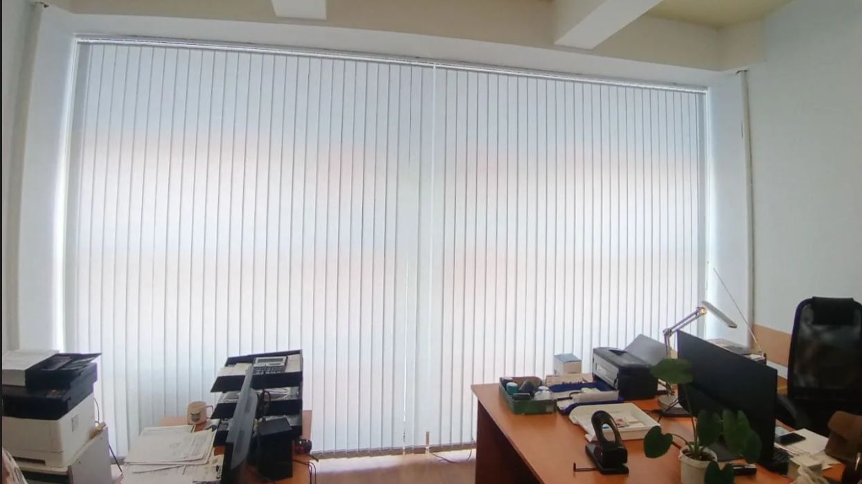 Практичные лаконичные и долговечные вертикальные жалюзи нейтрального цвета в офисное помещение.