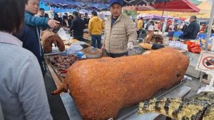 Мясо крокодила и запеченный целиком поросенок на рынке в провинции Гуандун, Китай