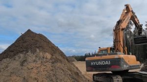 Просеивающий ковш для добычи чернозёма из вскрышных пород в лесу. Он разделяет корневища и чернозем