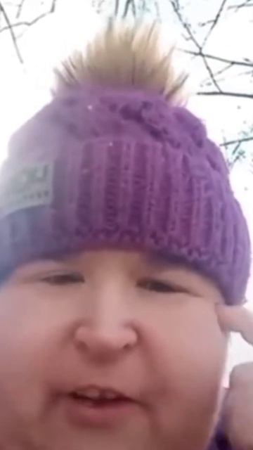 Женщина в фиолетовой шапке крутит пальцем у виска говорит думай мозгами Витюша