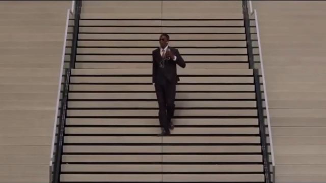 Мужчина в официальном костюме, в солнцезащитных очках, в наушниках танцует на улице, в метро, на лес