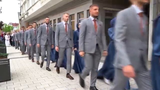 Группа студентов празднует выпускной на боснийской улиц.