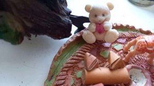 Глиняные игрушки на подоконнике - крокодил, лягушки, морские раковины и цветущие фиалки в апреле