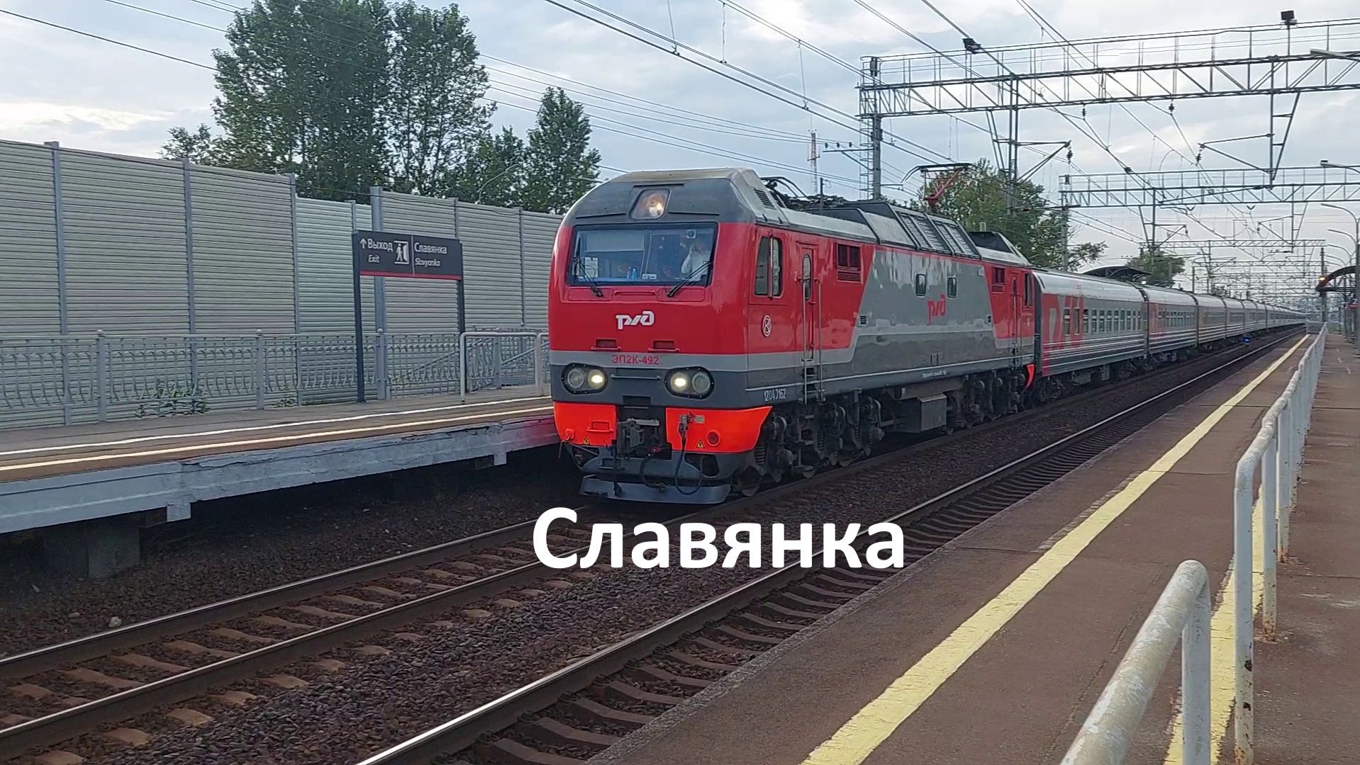 Пассажирский поезд Петербург - Москва: электропоезд ЭП2К пролетает платформу "Славянка" в 2024 году