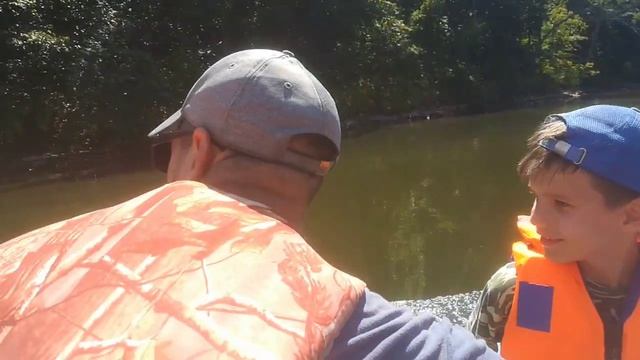 Сын учится управлять лодкой