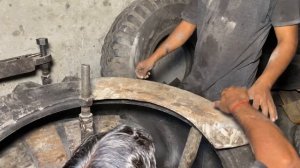 Процесс восстановления поврежденной боковины гигантской шины.