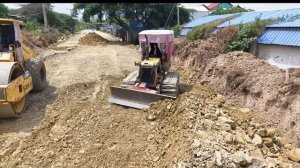 Process build foundation road in village pouring stone by mini bulldozer pushing with dump trucks-00