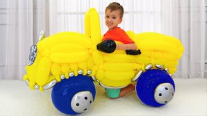 Влад и Никита играют с игрушечной машинкой из шариков.