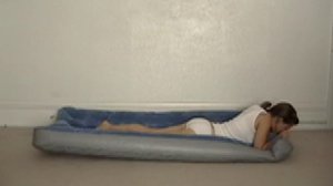 Girl inflate an inflatable mattress under herself