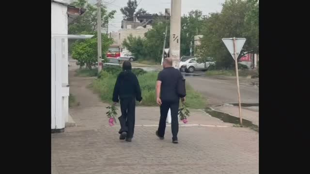 Люди несут цветы и мягкие игрушки к стихийному мемориалу в Старобельске