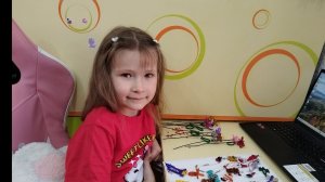 Соломония показывает брелки и цветы из бисера, которые она сделала сама