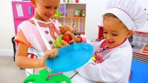Влад и Никита играют в ресторан и разносят игрушечные блюда.