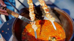 Суп с жаренным мясом, овощами и яйцами в казане на костре