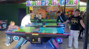 Ева и папа играют в аэро-хоккей