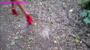 Девушка в красных босоножках на высоком каблуке идет по лесной тропинке. Превью
