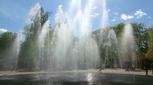 Люди бегают через фонтан в парке города Мытищи