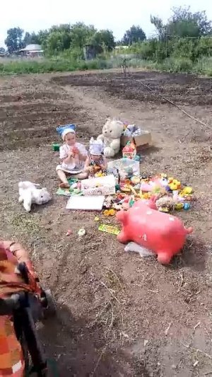 Дети перебирают игрушки, огород  жара.