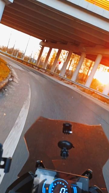 Скутер, слоумо, солнце из-под моста, мокрый асфальт, поворот
