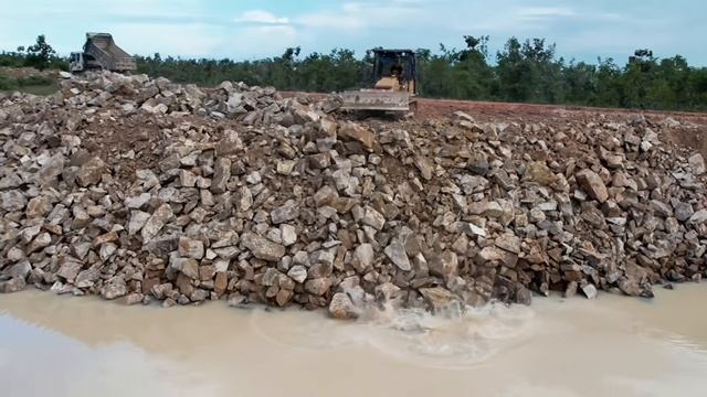 Clearing large rocks to drop down along the sidewalk of a deep pond смотреть онлайн