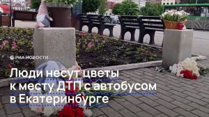 Люди несут цветы к месту ДТП с автобусом в Екатеринбурге