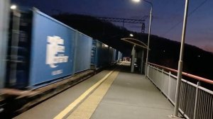 Электропоезд ЭД9МК-0100 и электровоз 3ЭС5К-181 «Ермак» с грузовым поездом следуют сквозь сумерки.