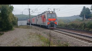 Электровоз 4ЭС5К-071 «Ермак» с грузовым поездом выходит из кривой,следуя на жёлтый сигнал светофора.