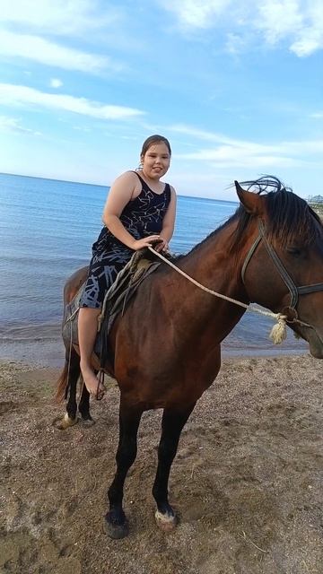 ВАРЮХА катается на лошади по берегу Каспийского моря в Дербенте.
