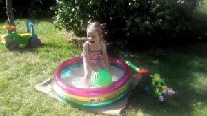 Детский бассейн Яна играет в бассейне лопает шарики с водой
