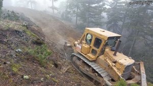 Бульдозер CAT D7 создает дорогу на склоне горы.