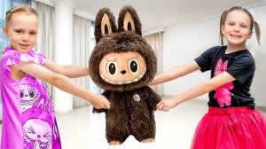 Девочки играют и учатся делиться с Лабубу