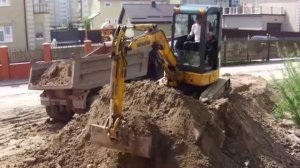 Аренда миниэкскаватора - погрузка грунта в самосвал.
