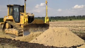 БУЛЬДОЗЕР НА ГУСЕНИЦАХ ДЕЛАЕТ ПЛАНИРОВКУ ГРУНТА