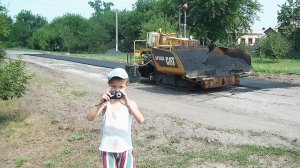 Асфальтоукладчик и каток, дорожная техника в работе.