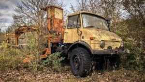 Мужчина восстанавливает брошенный грузовик с манипулятором.