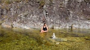 Девушка в соблазнительном купальнике купается в водопаде
