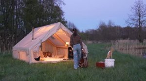 Девушка в одиночестве в кемпинге с собакой. Уютная палатка, приготовление еды на дровяной печи.