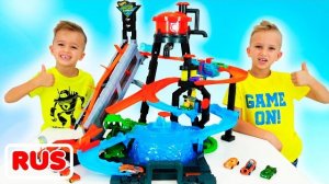 Влад и Никита строят город Hot Wheels. У детей есть дорожки и много машин. Детям весело играть