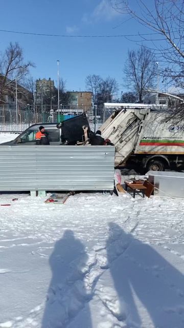 Мусоровоз прессует мусор.