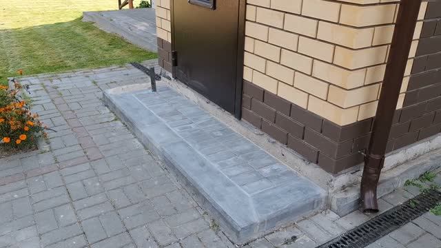 Приступок к крыльцу частного дома из бетонного бордюра.