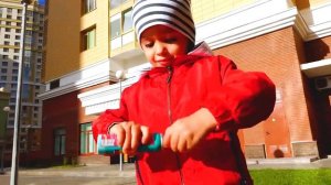 Никита играет в автомойку с красной детской машинкой